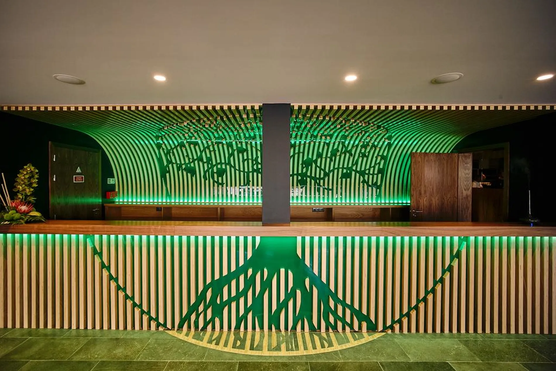 Recep&ccedil;&atilde;o com design verde e madeira, luzes e decora&ccedil;&atilde;o de plantas.