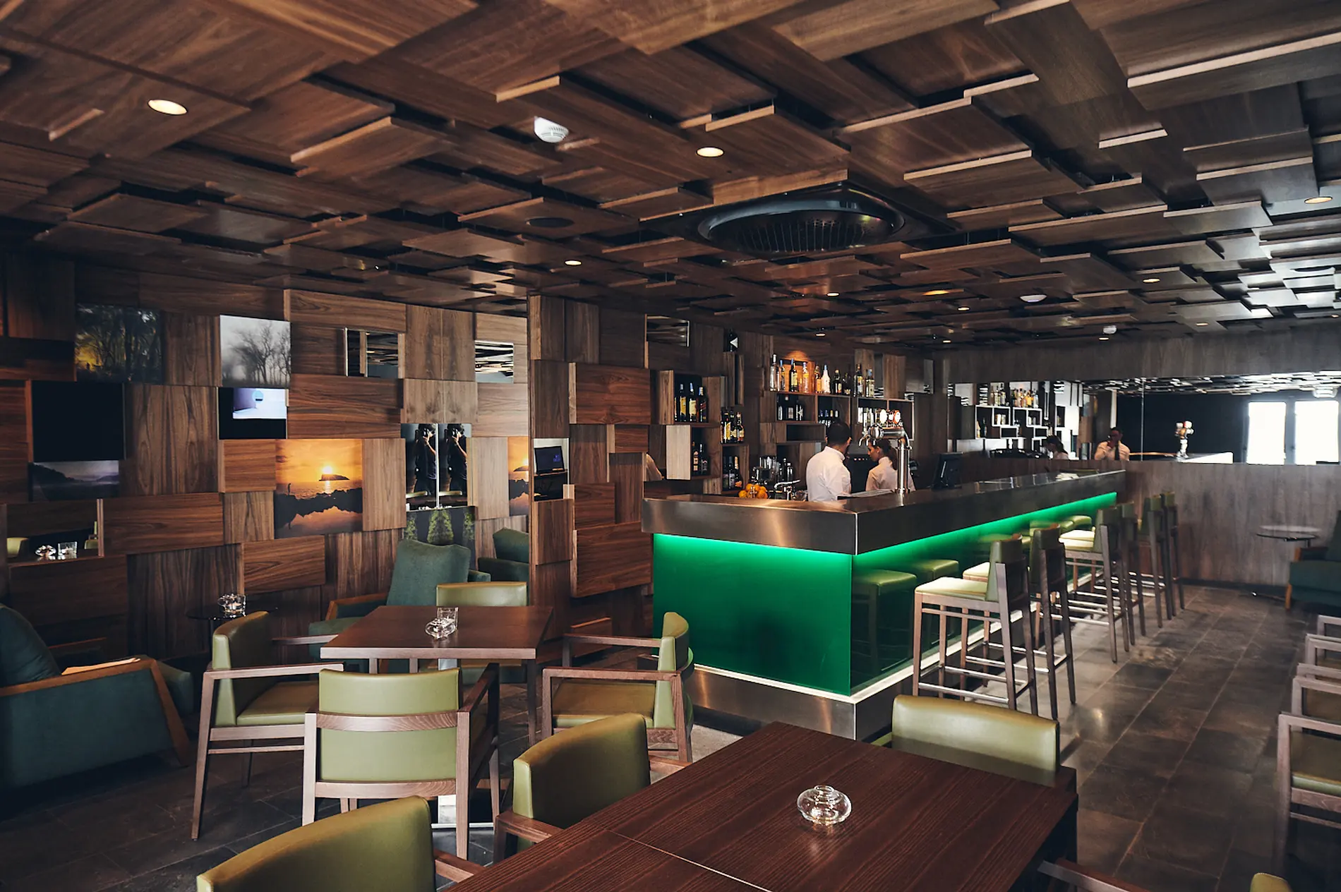 Bar elegante com balc&atilde;o iluminado, decora&ccedil;&atilde;o de madeira e assentos modernos.