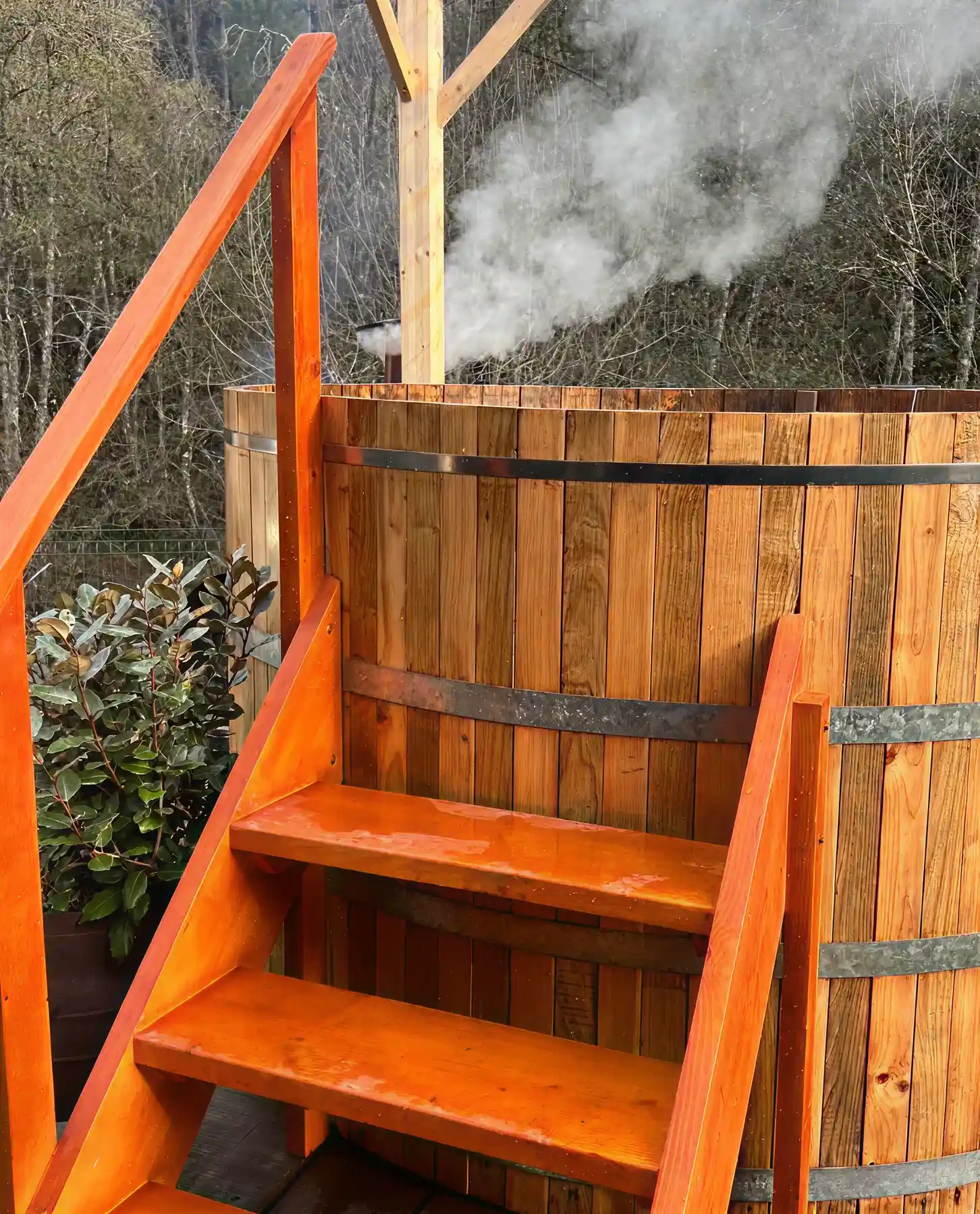Escada laranja leva a ofur&ocirc; de madeira com fuma&ccedil;a ao fundo.