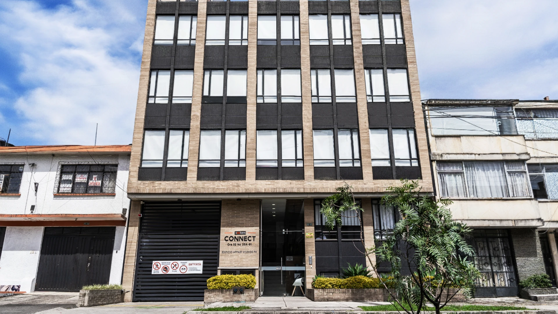 Edificio de oficinas moderno con fachada de ladrillo y ventanas negras.