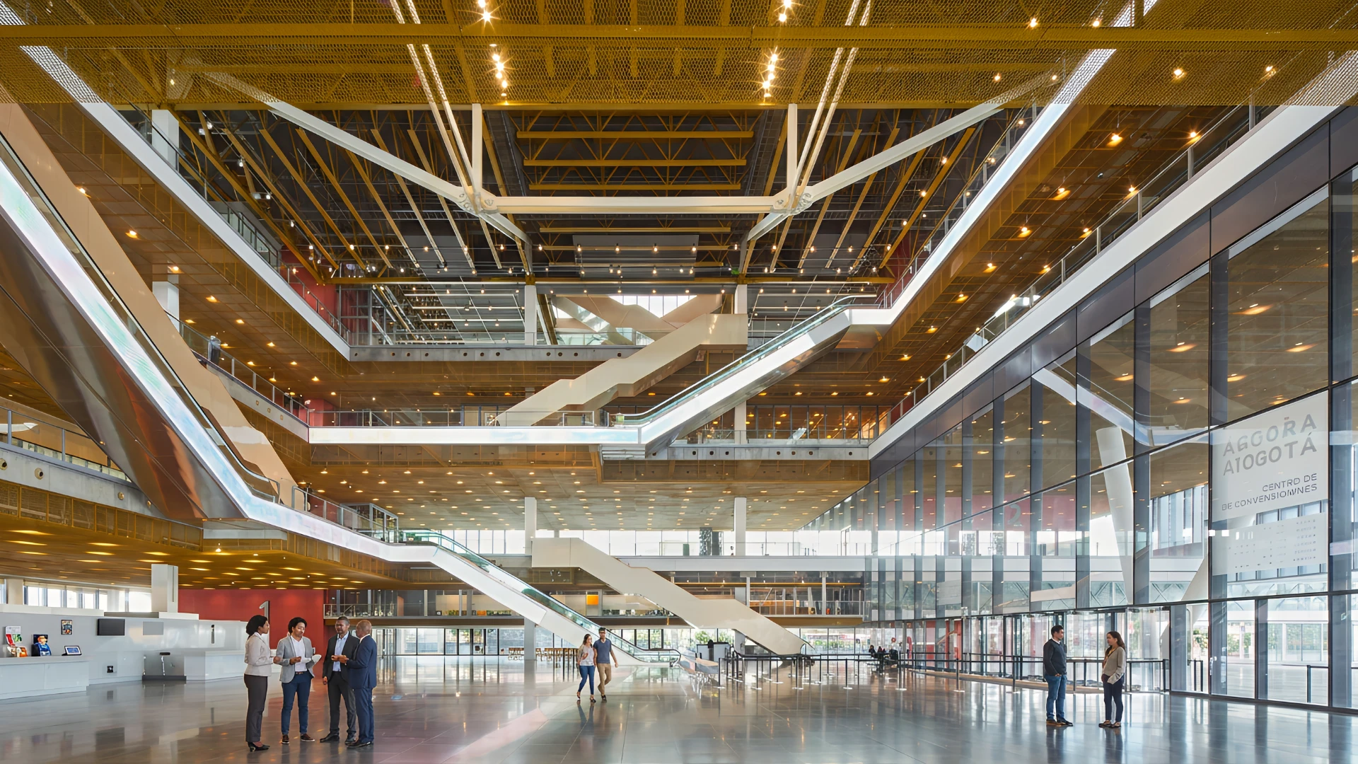 Interior moderno de un centro de convenciones con escaleras y personas conversando.
