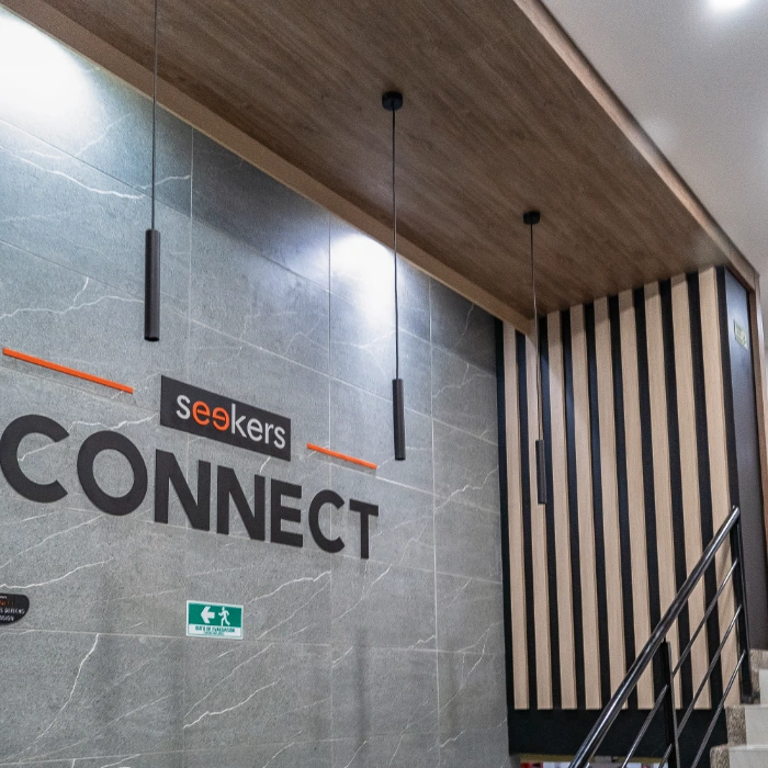 Pared decorativa con letras: "seekers CONNECT" y luz colgante moderna.