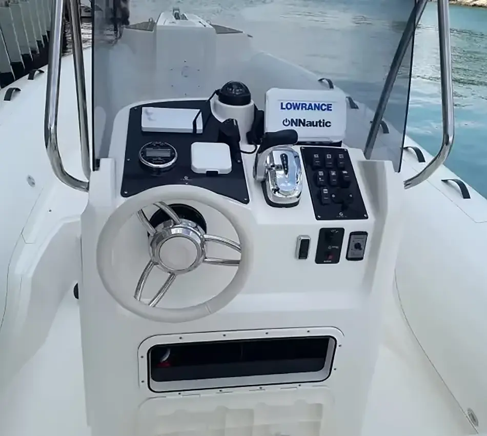Consola de control de lancha con volante y dispositivos electr&oacute;nicos.