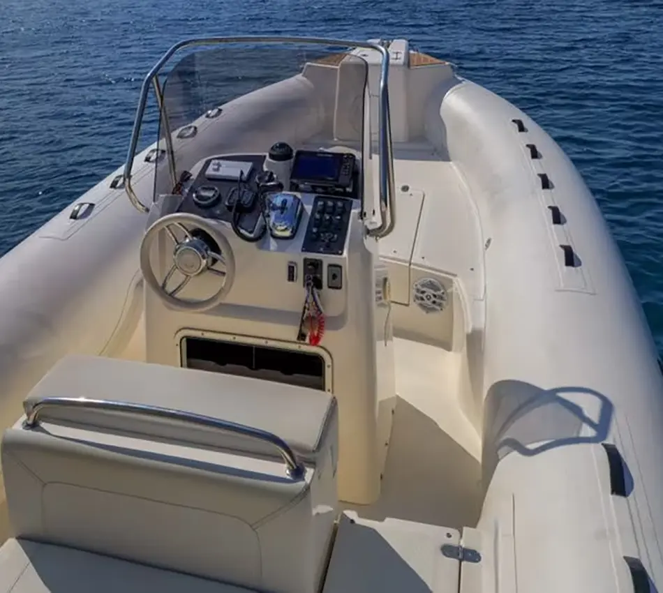 Barco inflable blanco con consola de mando y volante en el mar.