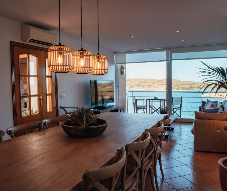 Comedor elegante con vistas al mar y decoraci&oacute;n moderna.