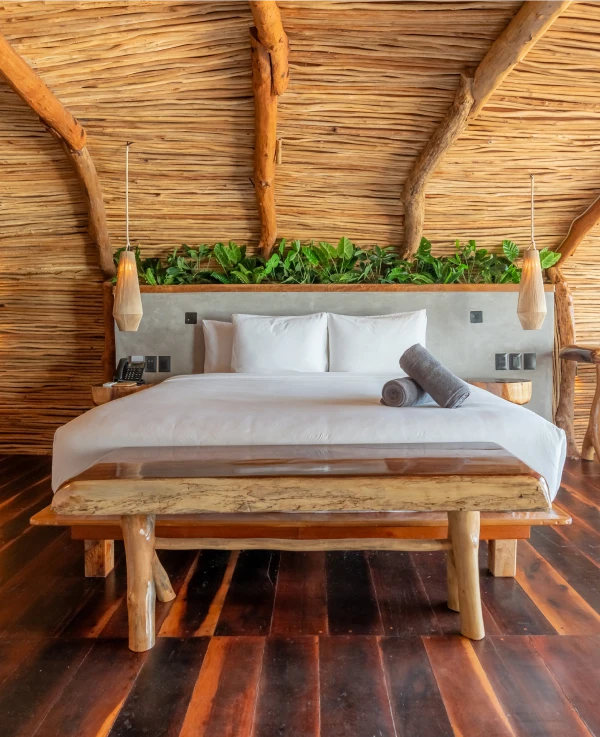 Rustic bedroom with wooden decor and lush greenery.