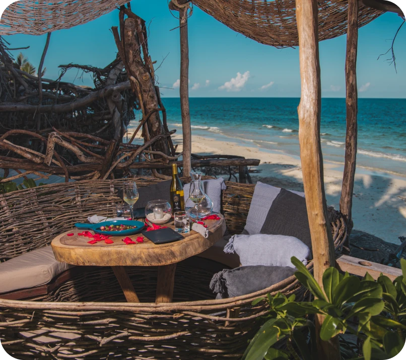 Rustic beachside table setting with wine and snacks.