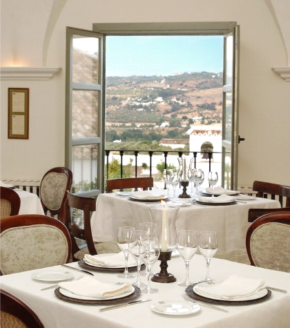 Restaurante elegante con mesas dispuestas y vista a un paisaje monta&ntilde;oso.