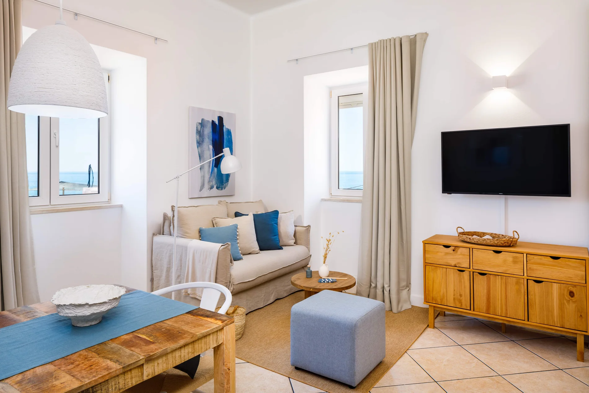 Cozy living room with ocean view, wooden furniture, and blue accents.