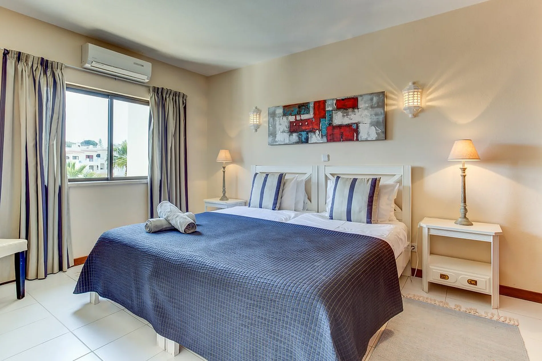 Cozy bedroom with a double bed, lamps, and a window view.