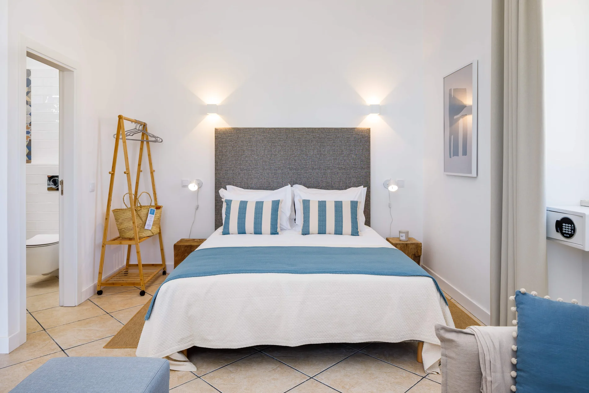 Modern bedroom with blue accents, double bed, and soft lighting.