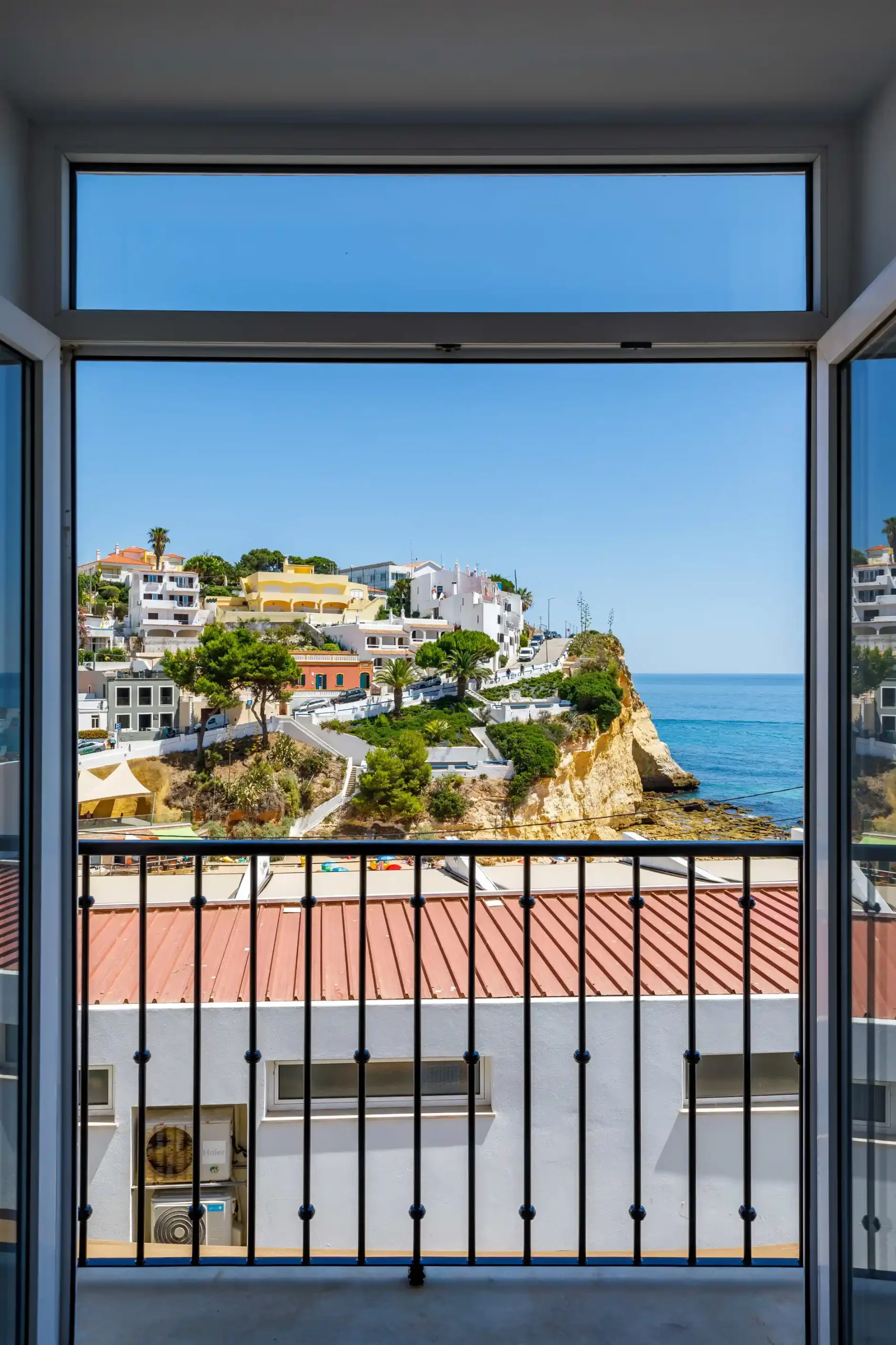View of coastal town through open window on a sunny day.