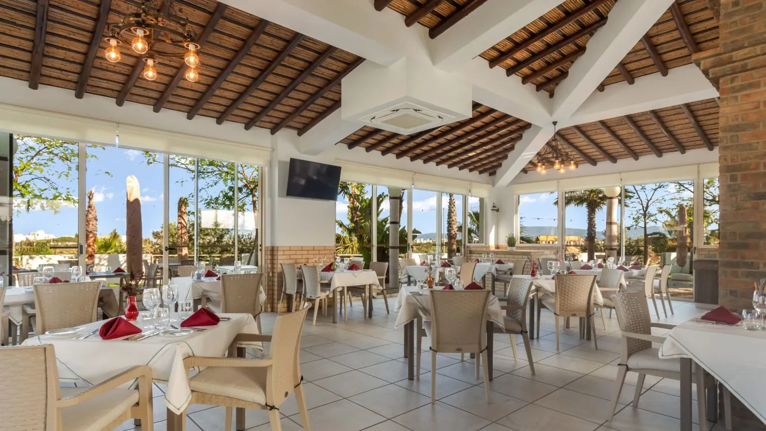 Spacious restaurant with large windows and neatly set tables.
