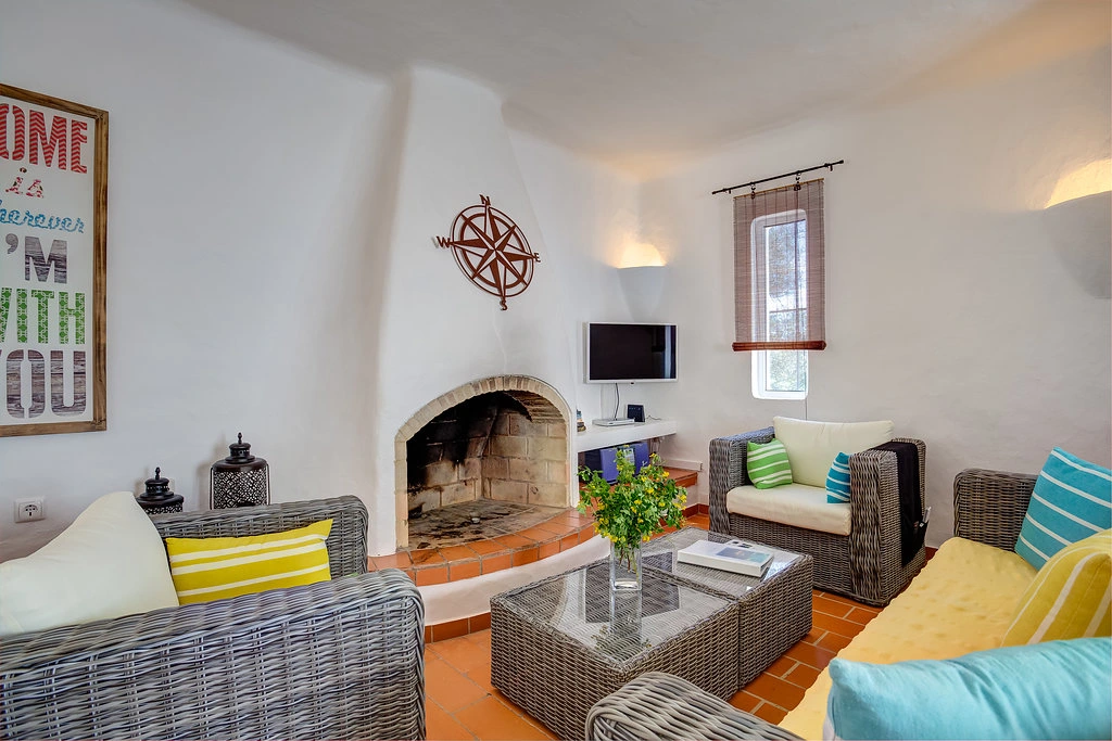 Cozy living room with wicker furniture and fireplace.