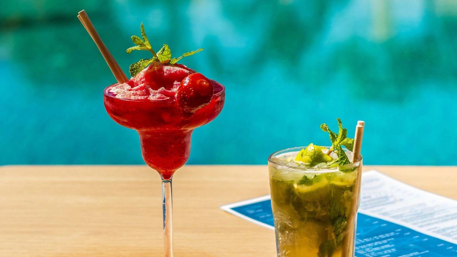 Two refreshing cocktails by a pool.