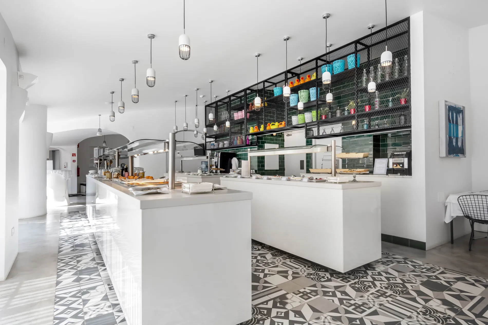 Modern, bright cafe interior with patterned floor and pendant lights.