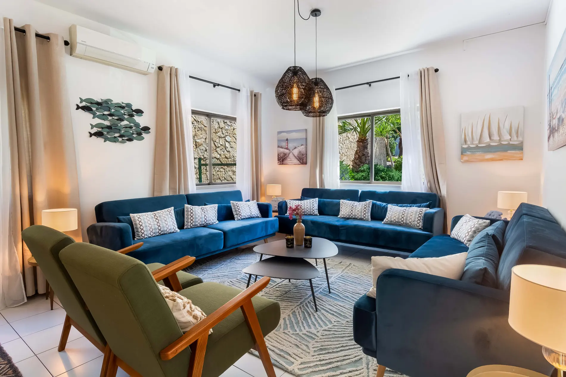 A cozy living room with blue sofas and modern decor.