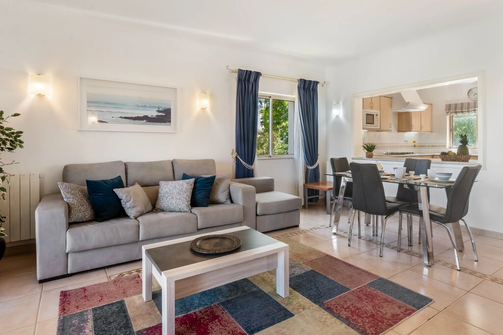 Modern living and dining area with gray sofa and blue accents.