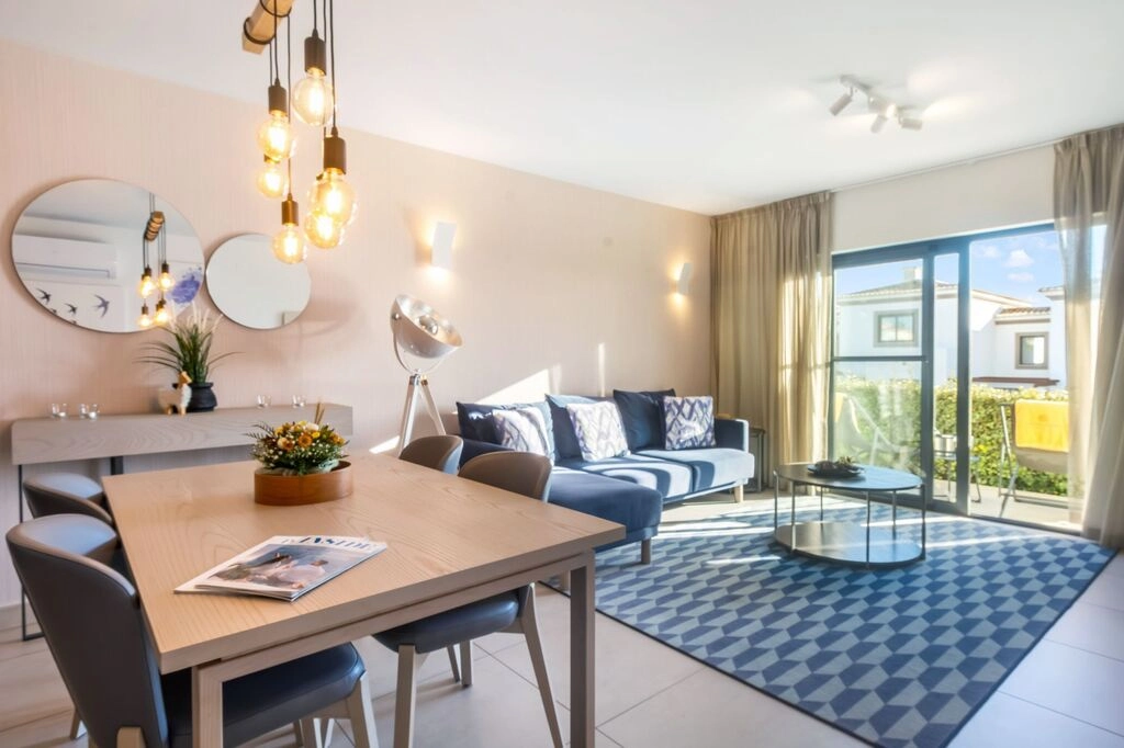 Modern living room with sofa, dining table, and large windows.