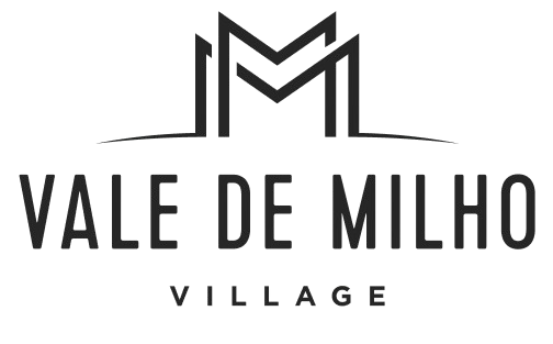 Black logo with "Vale de Milho Village" text and abstract "M" design.