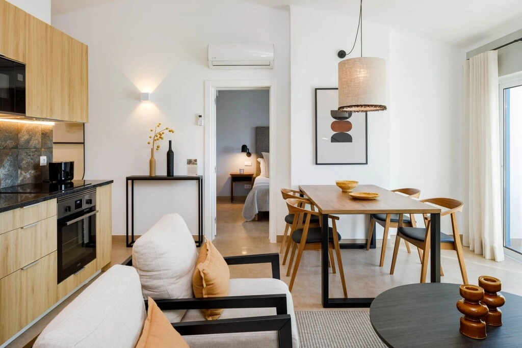 Modern living area with kitchen, dining table, and cozy seating.