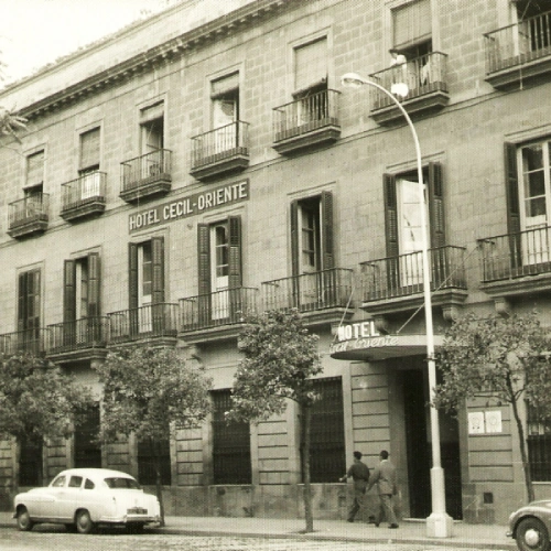 Antiguo edificio del Hotel Cecil-Oriente con coches y &aacute;rboles enfrente.
