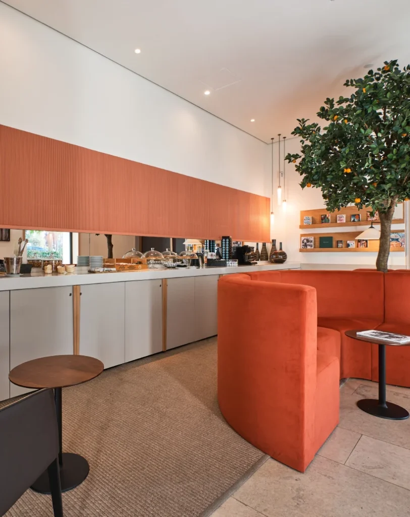 Cafeter&iacute;a moderna con decoraci&oacute;n c&aacute;lida y planta interior.