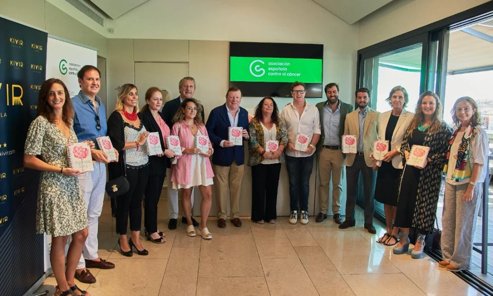 Un grupo de personas sostiene libros frente a una pantalla verde.