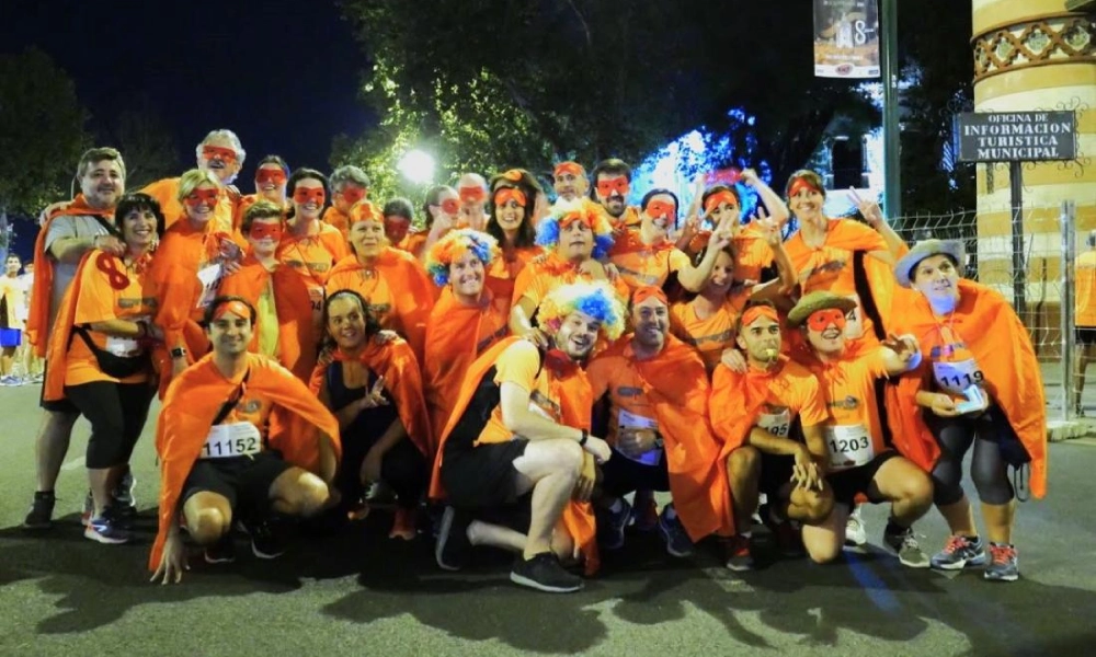 Grupo de personas disfrazadas de superh&eacute;roes en un evento nocturno.