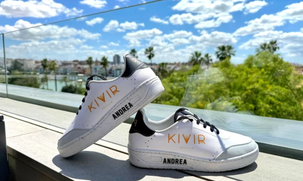 Zapatillas blancas con letras, fondo de cielo y &aacute;rbol.
