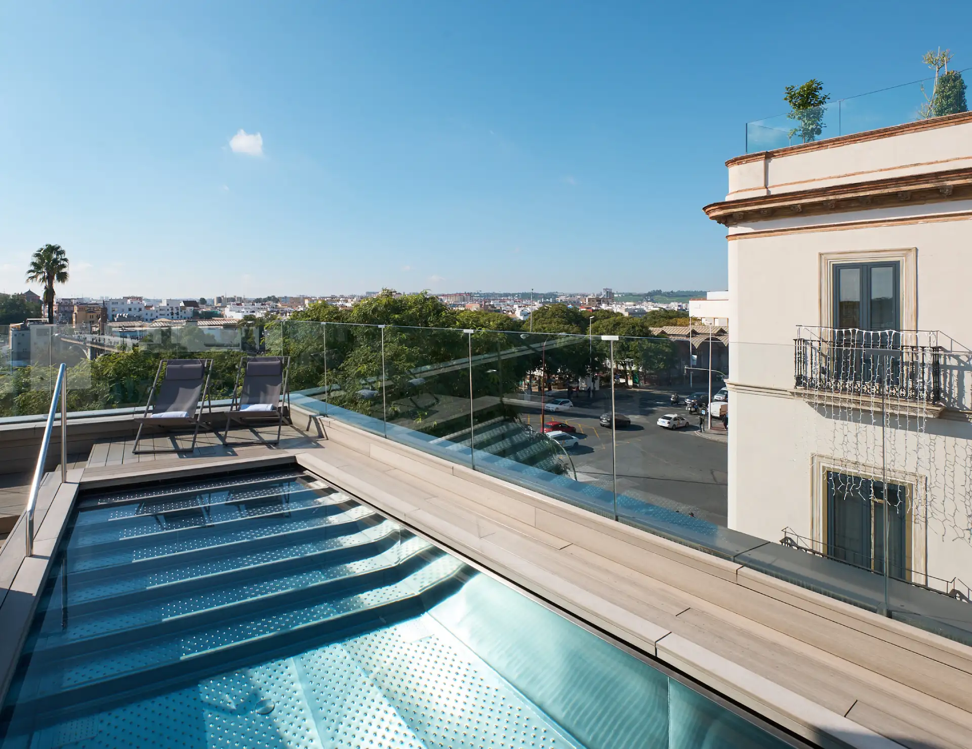Terraza con piscina, tumbonas y vistas panor&aacute;micas de la ciudad.