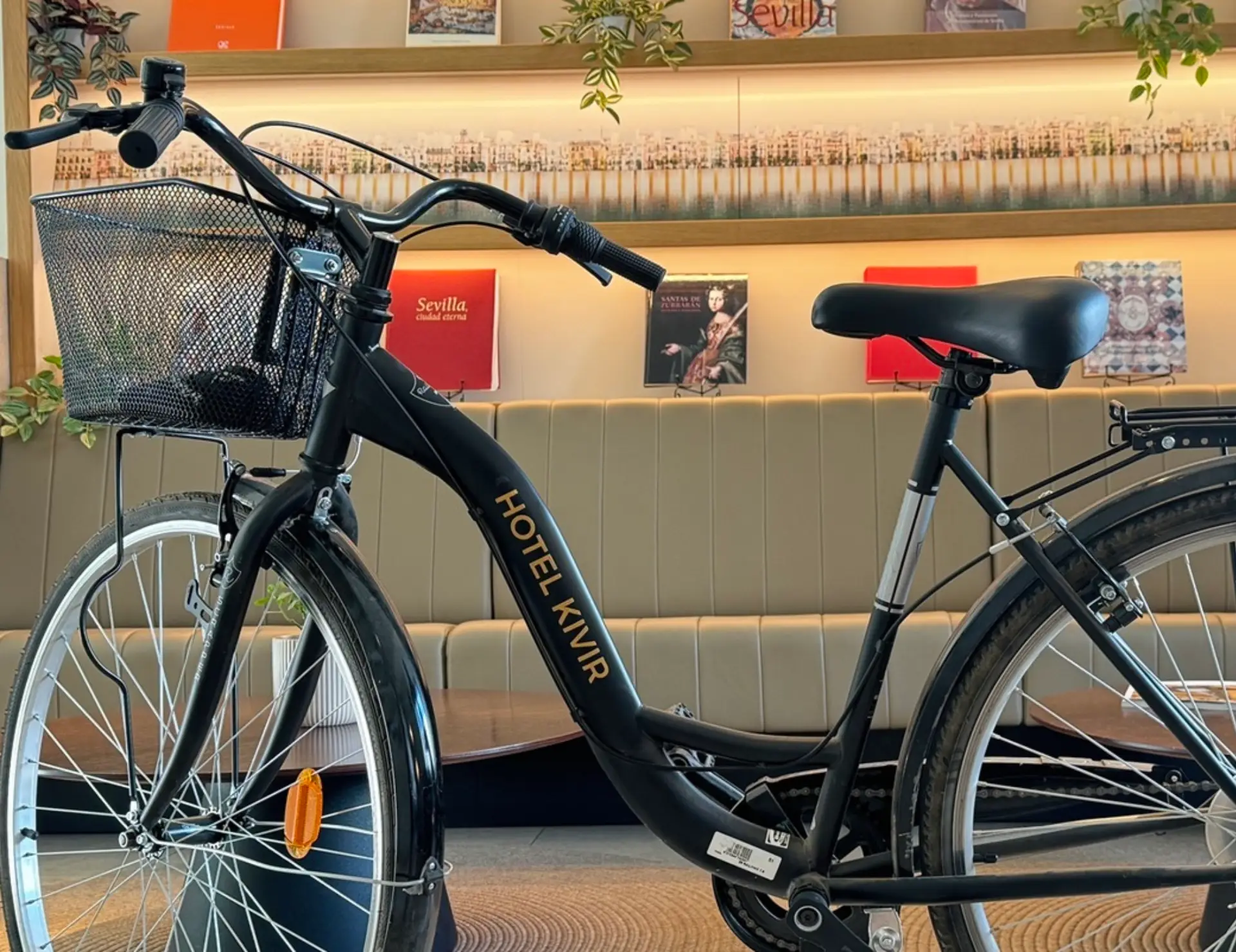 Bicicleta negra con canasta frontal y texto "Hotel Kivir" en el cuadro.