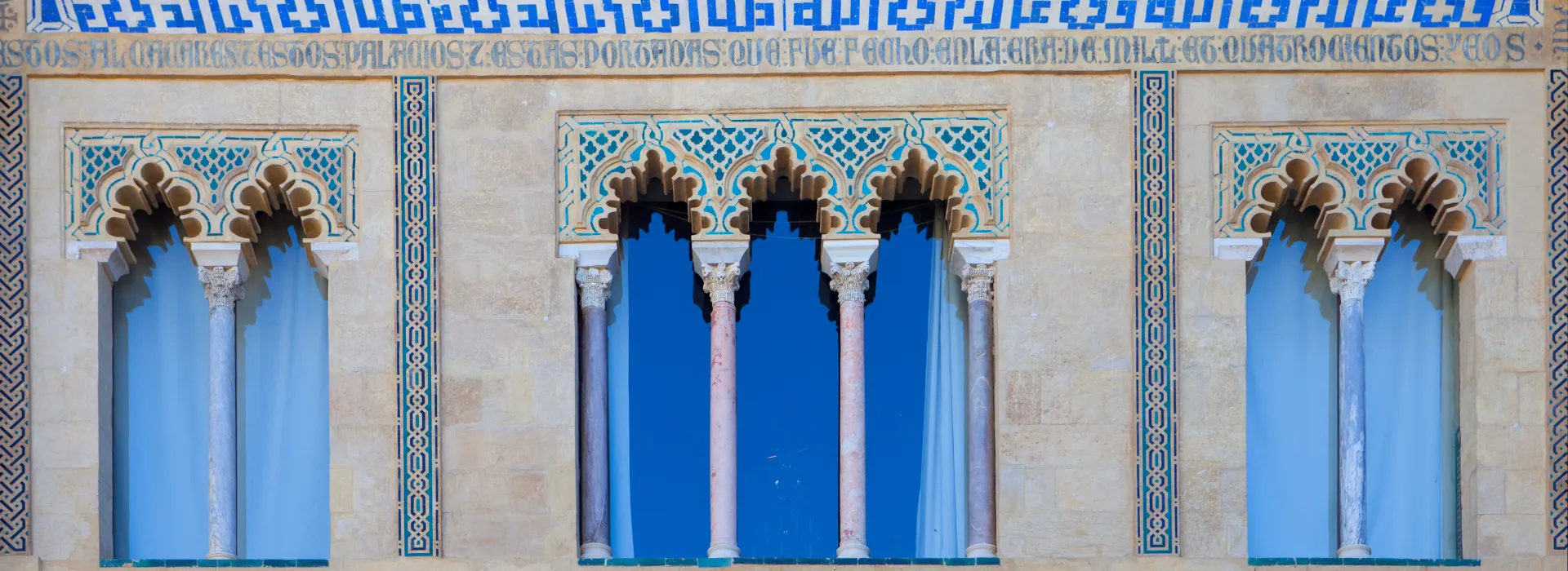 Ventanas con arcos y decoraci&oacute;n azul en un edificio hist&oacute;rico.