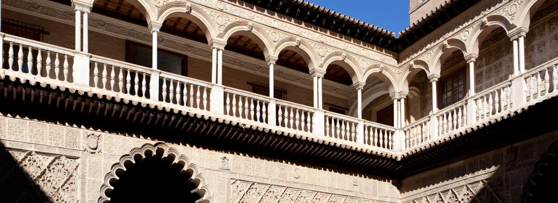 Balc&oacute;n con arcos en un edificio hist&oacute;rico con detalles ornamentales.