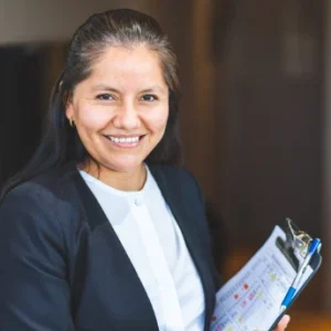 Persona sonriendo con una carpeta con gr&aacute;ficos en la mano.