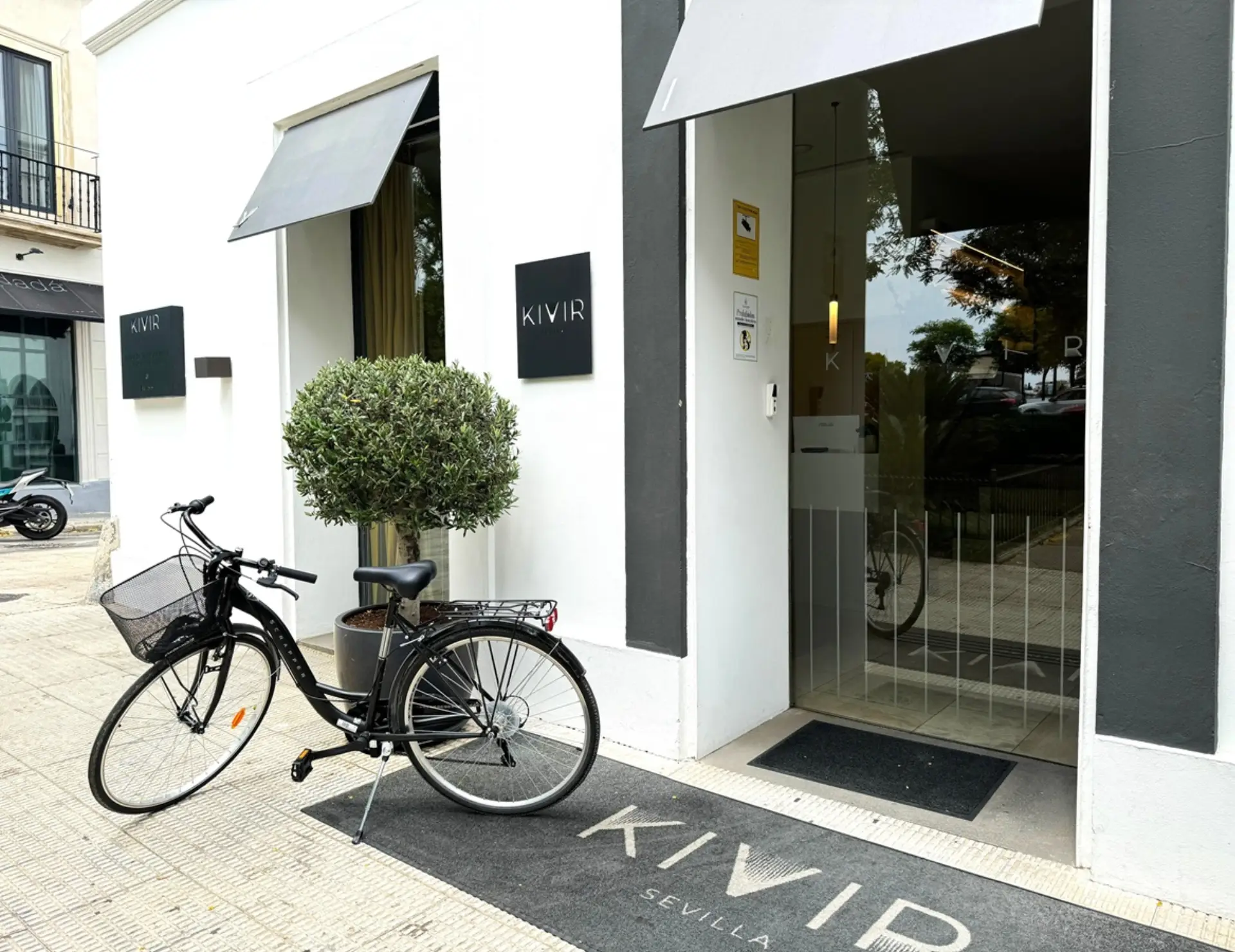 Entrada moderna con bicicleta y letreros KIVIR en la pared