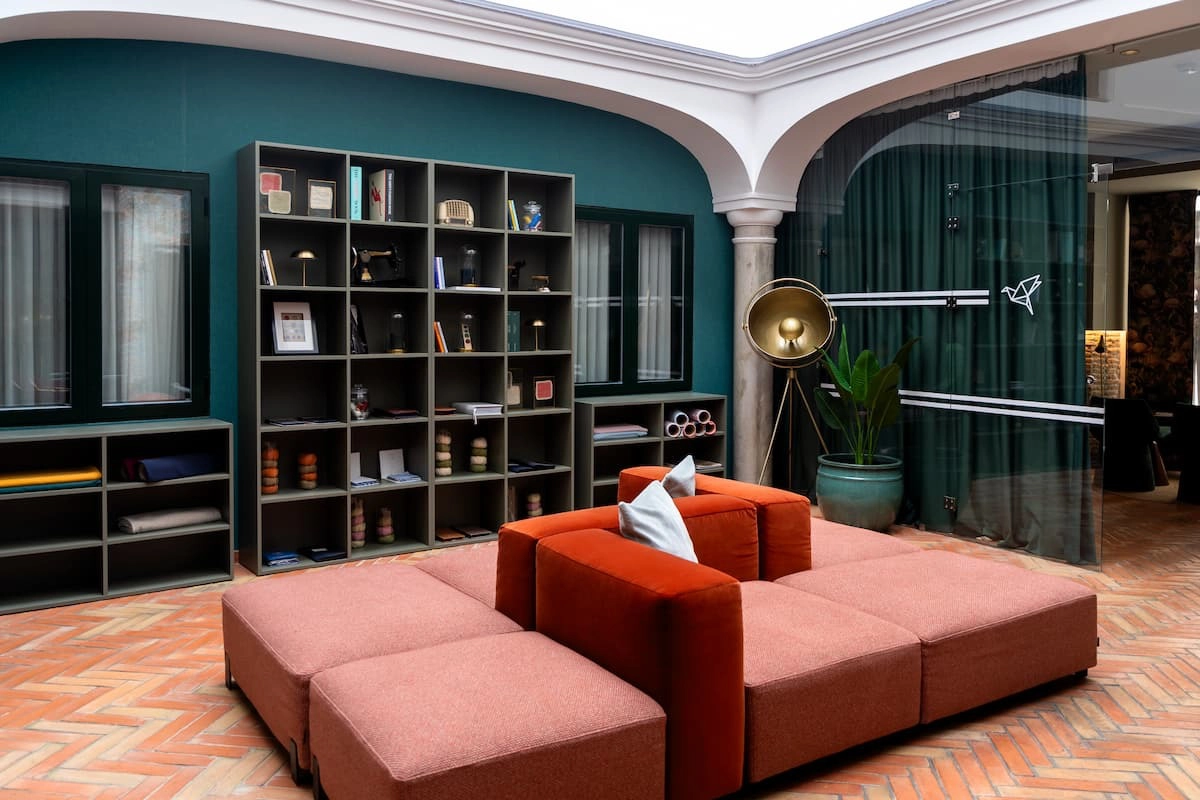 Sala con estantería, sofá modular y decoración moderna.