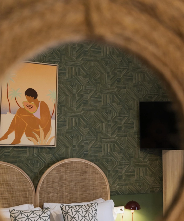 Habitaci&oacute;n con espejo redondo y arte de figura con fruta en la pared verde.