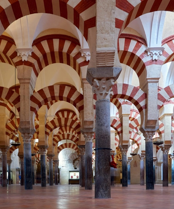 Arcos de columnas en un edificio con franjas rojas y blancas.