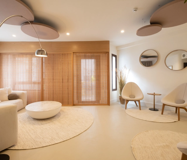 Sala moderna con sillas, mesa redonda y decoraci&oacute;n minimalista.