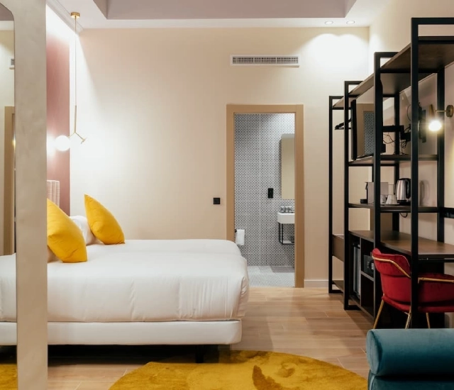 Habitaci&oacute;n moderna con cama doble, ba&ntilde;o, escritorio y decoraci&oacute;n acogedora.
