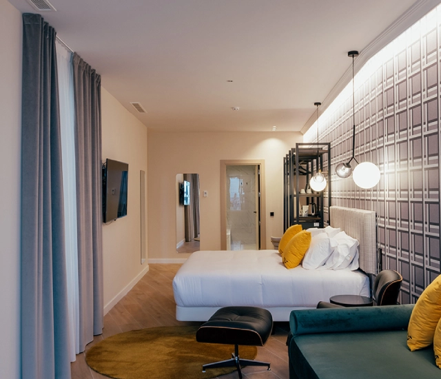 Habitaci&oacute;n moderna con cama, sill&oacute;n y decoraci&oacute;n minimalista.