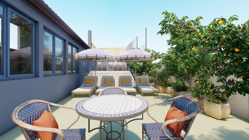 Terraza con mesa, sillas, tumbonas y árboles frutales bajo un cielo despejado.