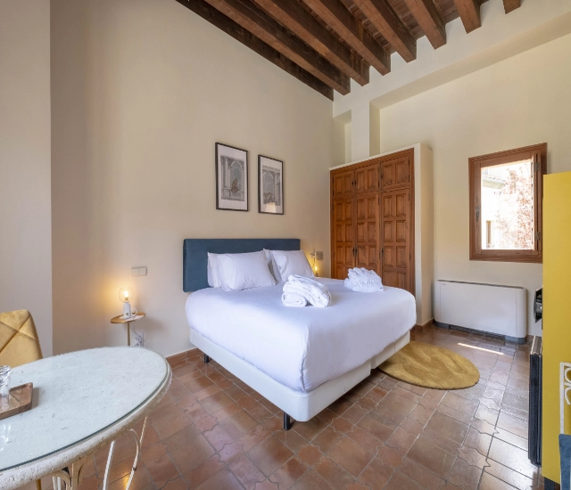 Habitaci&oacute;n luminosa con cama doble, decorada en estilo moderno y minimalista.