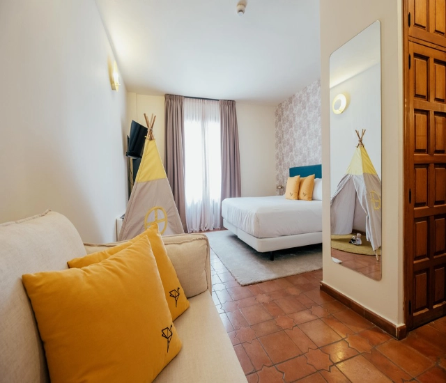 Habitaci&oacute;n con cama, tipi infantil y espejo al lado de la puerta.