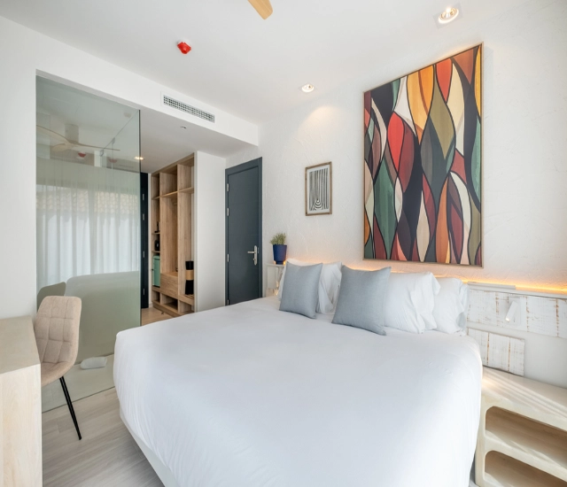 Dormitorio moderno con cama doble y pintura colorida en la pared.
