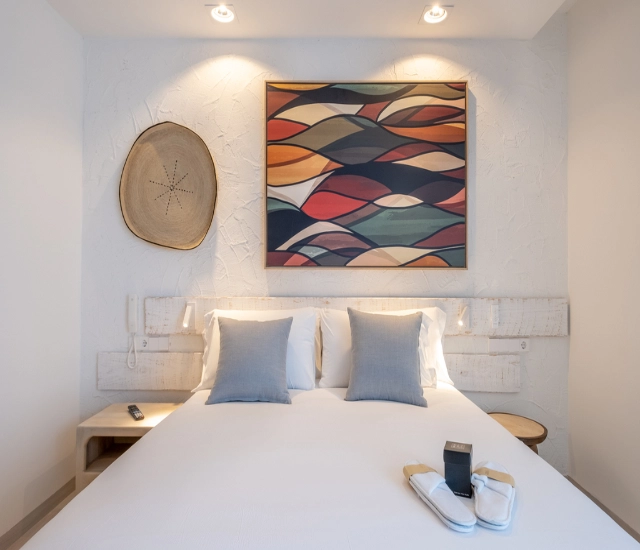 Dormitorio moderno con cama doble y arte colorido en la pared.