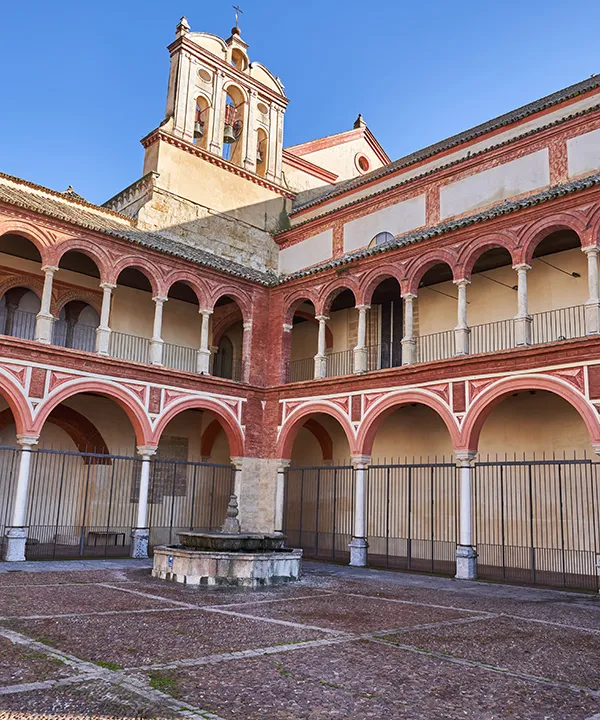 Patio interior con arcos y fuente en un edificio de estilo hist&oacute;rico.