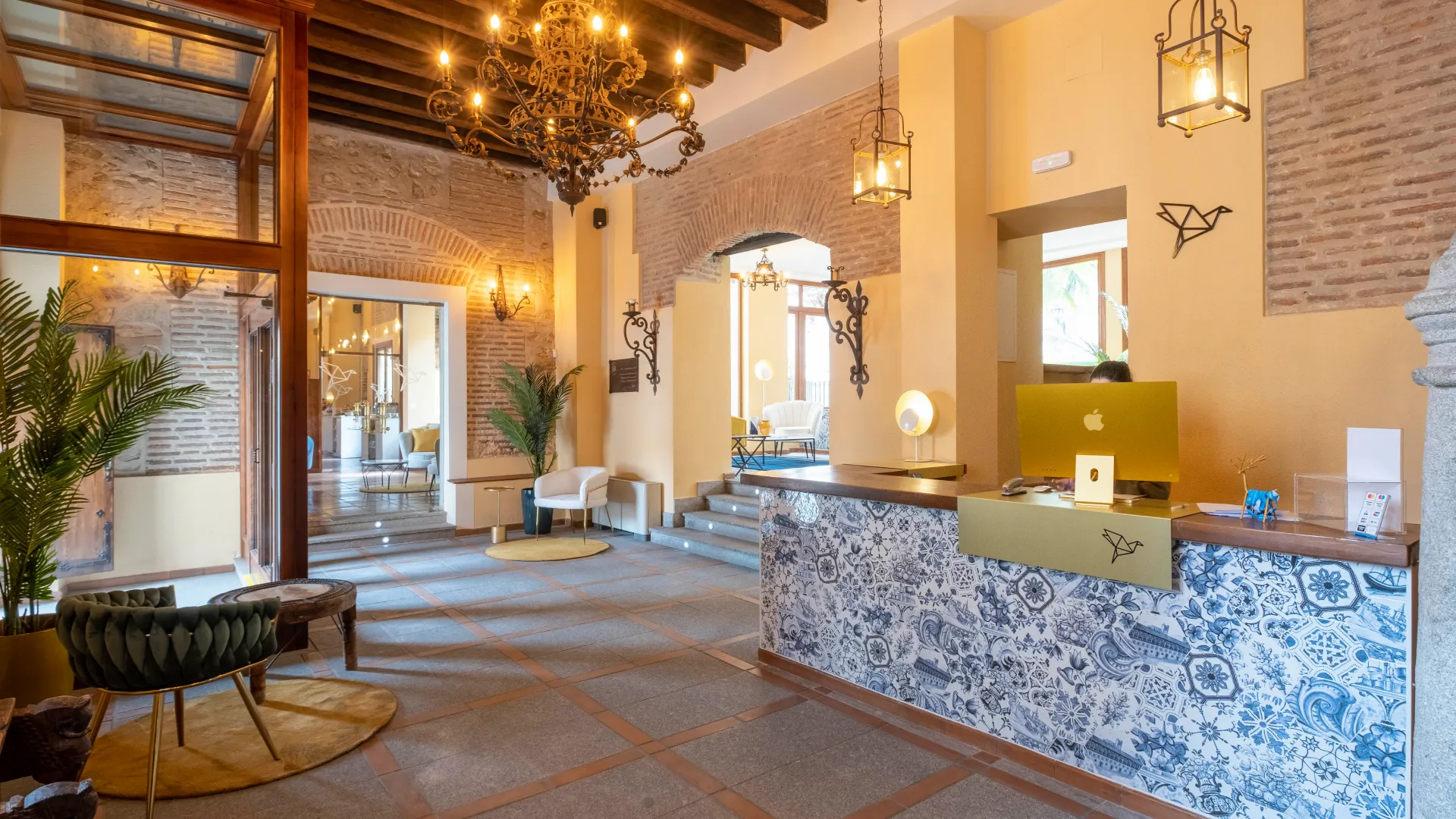 Vestíbulo con decoración elegante, mostrador de recepción y araña de luces.