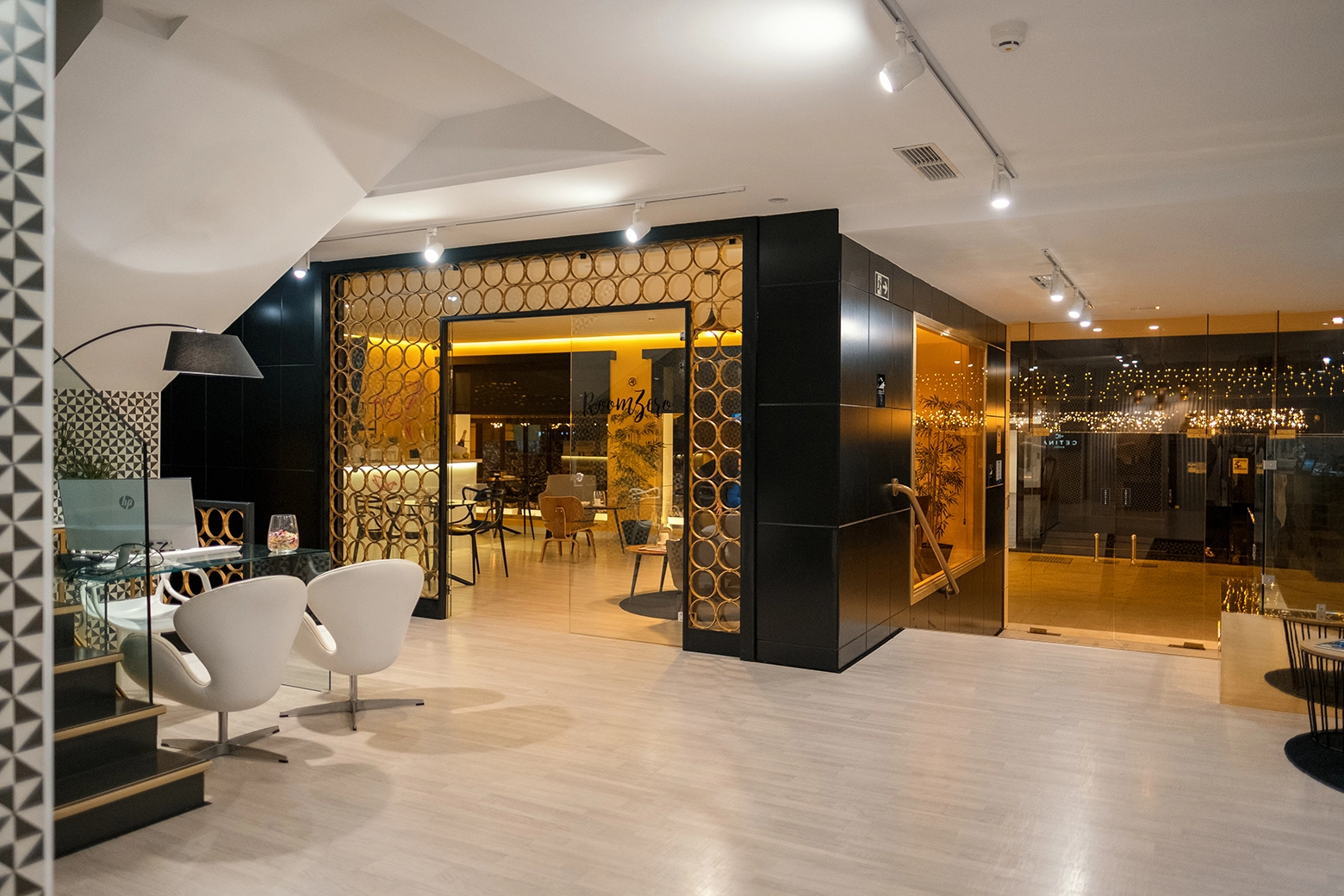 Espacio moderno con sillas blancas y decoración iluminada en el interior.